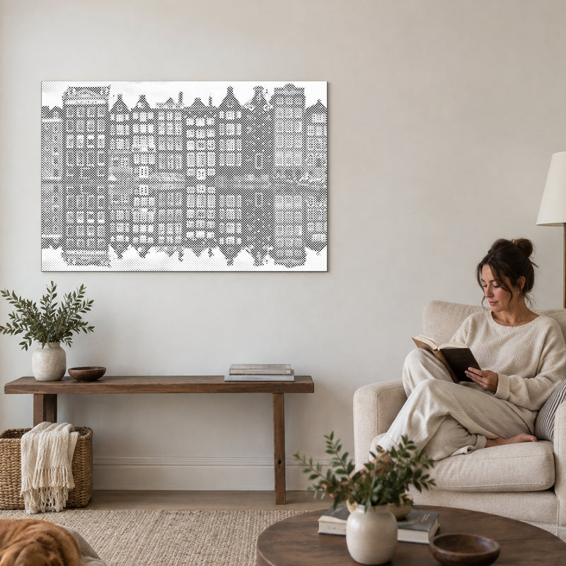Dot-painting canvas “Amsterdam Houses”, on a living-room wall with a person reading in an armchair nearby.