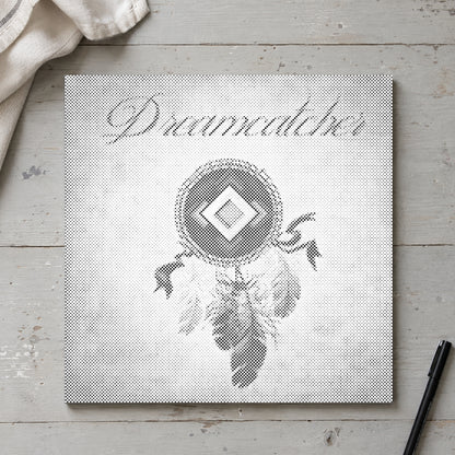 Dot-painting canvas “Dreamcatcher with Feathers”, seen from above on a worktable in soft daylight.