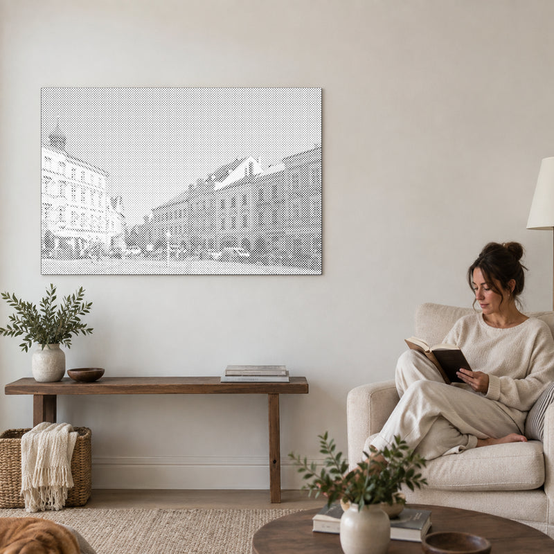 Dot-painting canvas “Jindrichuv Hradec”, on a living-room wall with a person reading in an armchair nearby.